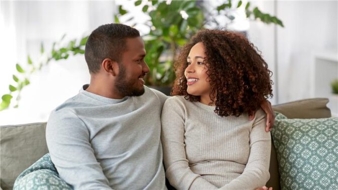 An african american couple sitting on a couch representing frozen donor eggs.