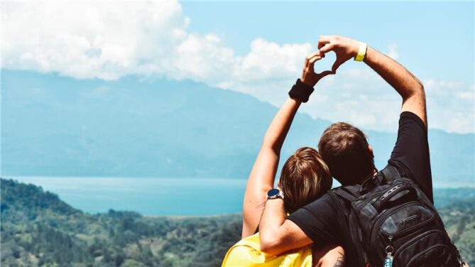 A couple out in the mountains holding their hands up lovingly representing Sperm Bank Process.