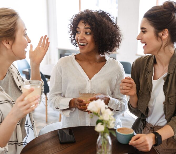 Three women talking at a coffee shop representing egg donation age limit.