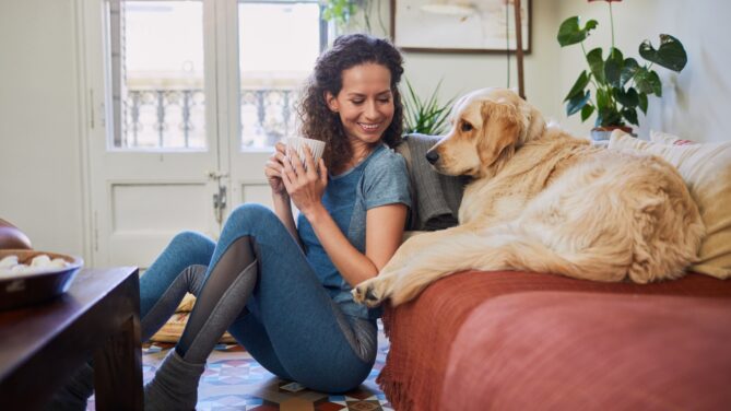 I woman sitting beside her couch next to her dog represents sperm donors for single women