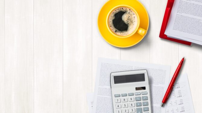 white table with a calculator, pen, and paper representing sperm donor cost.