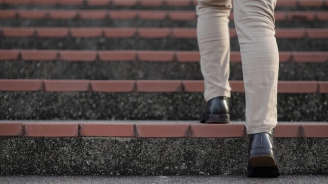 Man outside walking up a staircase. Representing how to find a sperm donor.