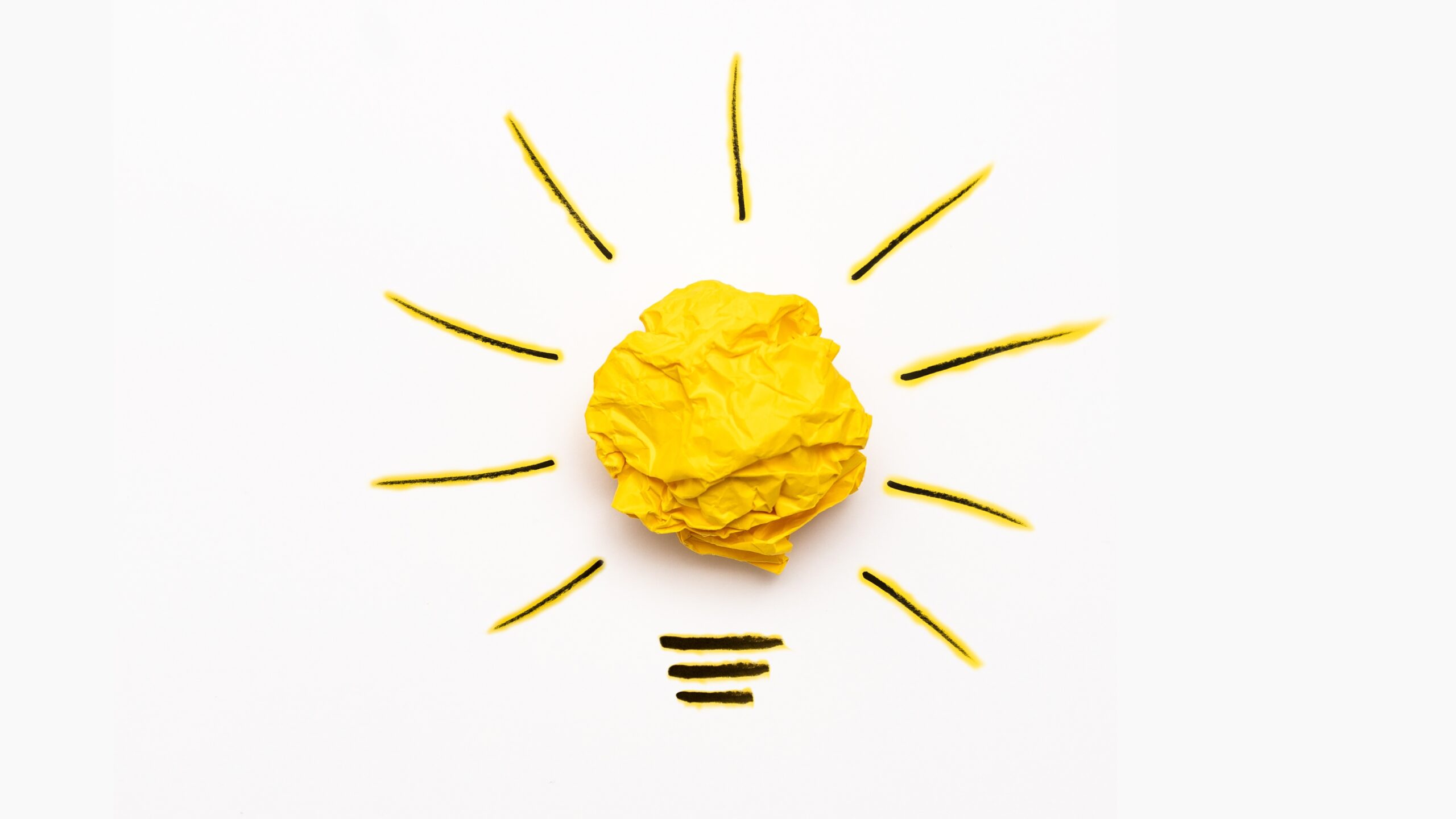 A yellow paper lightbulb thats centered on a off white background representing the ideas of how to find donor eggs.