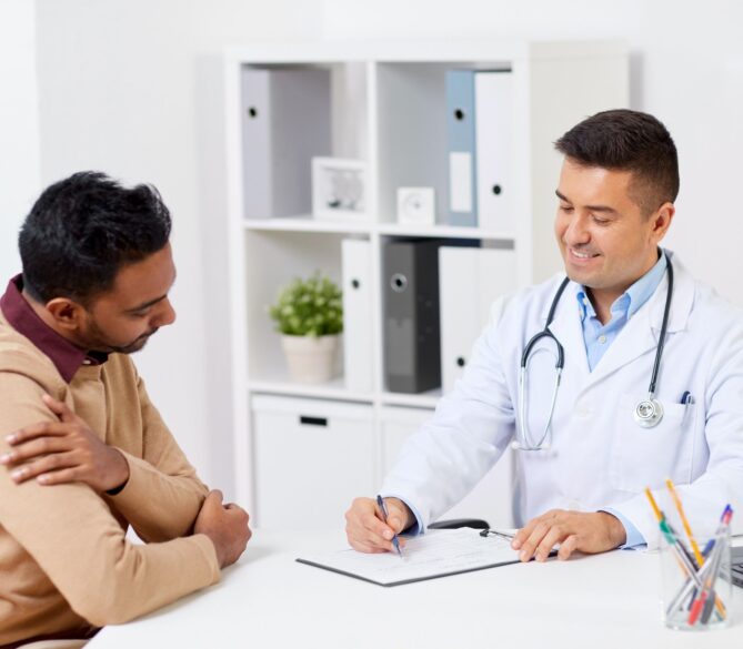 A doctor talking with a man in a medical office representing How to Be a Sperm Donor.