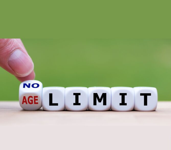 A set of dice that spells out no age limit on a wooden table in front of a green background representing what age can you donate sperm.