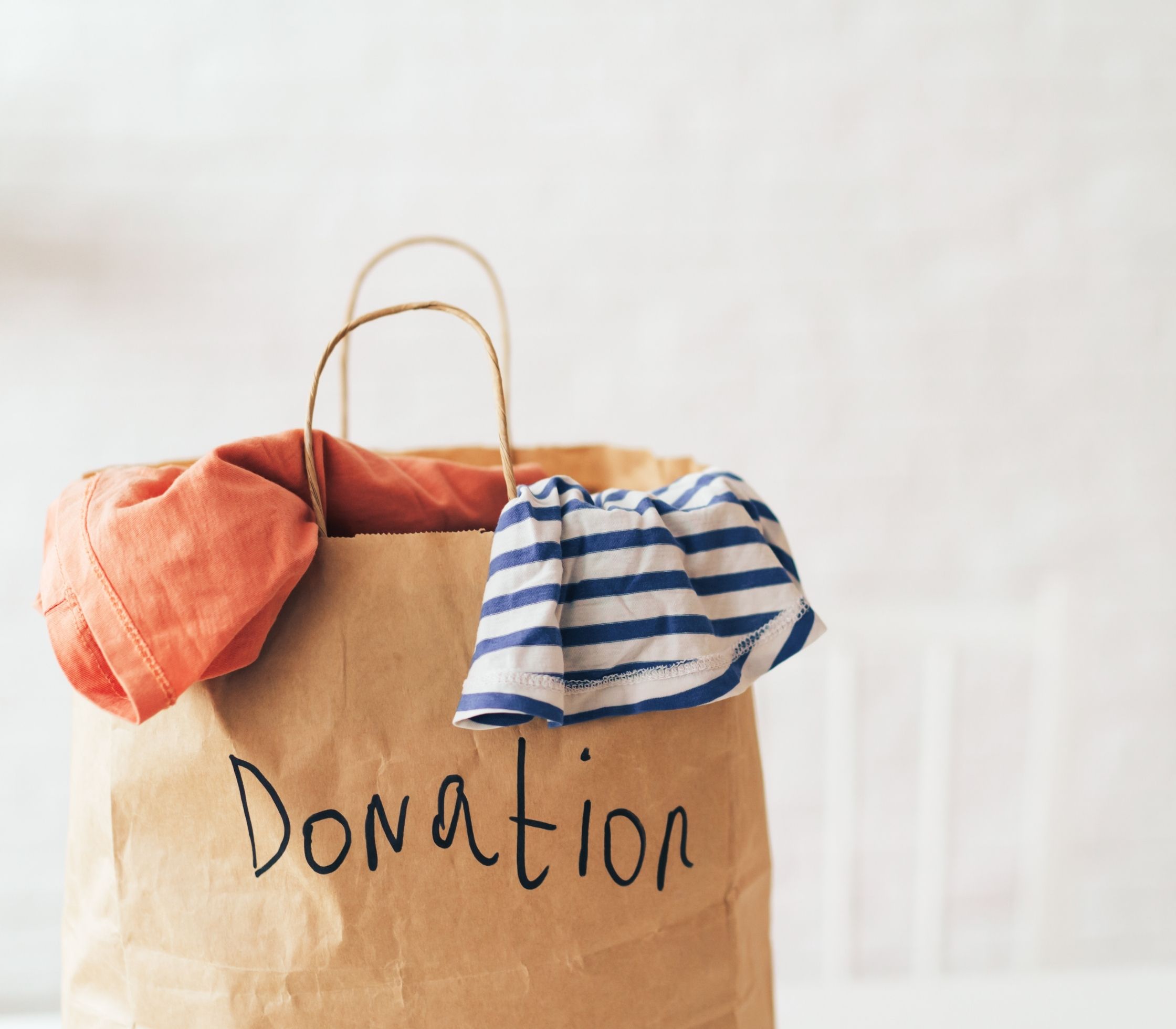 A brown paper bag labeled, donation, containing clothes represents what egg donation is not.